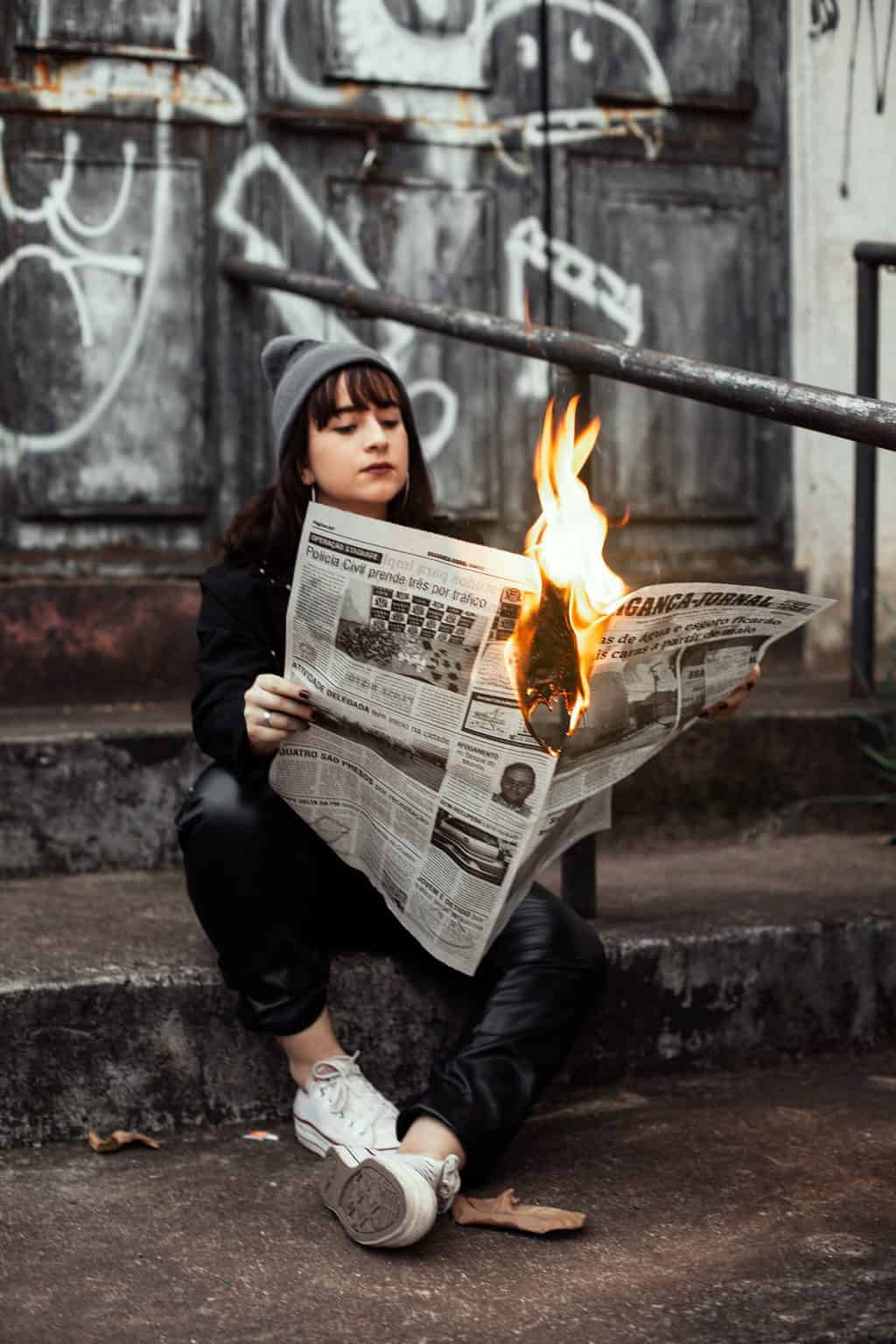 woman holding newspaper while burning 3422053 scaled 1